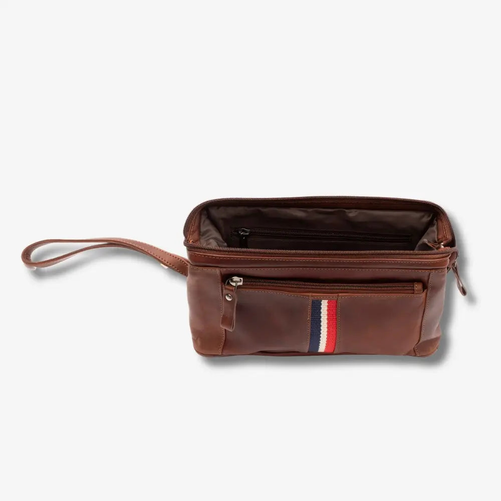A tan leather pouch with a wrist strap, shown open to reveal its interior. The front pocket features a signature vertical stripe in red, white, and blue.