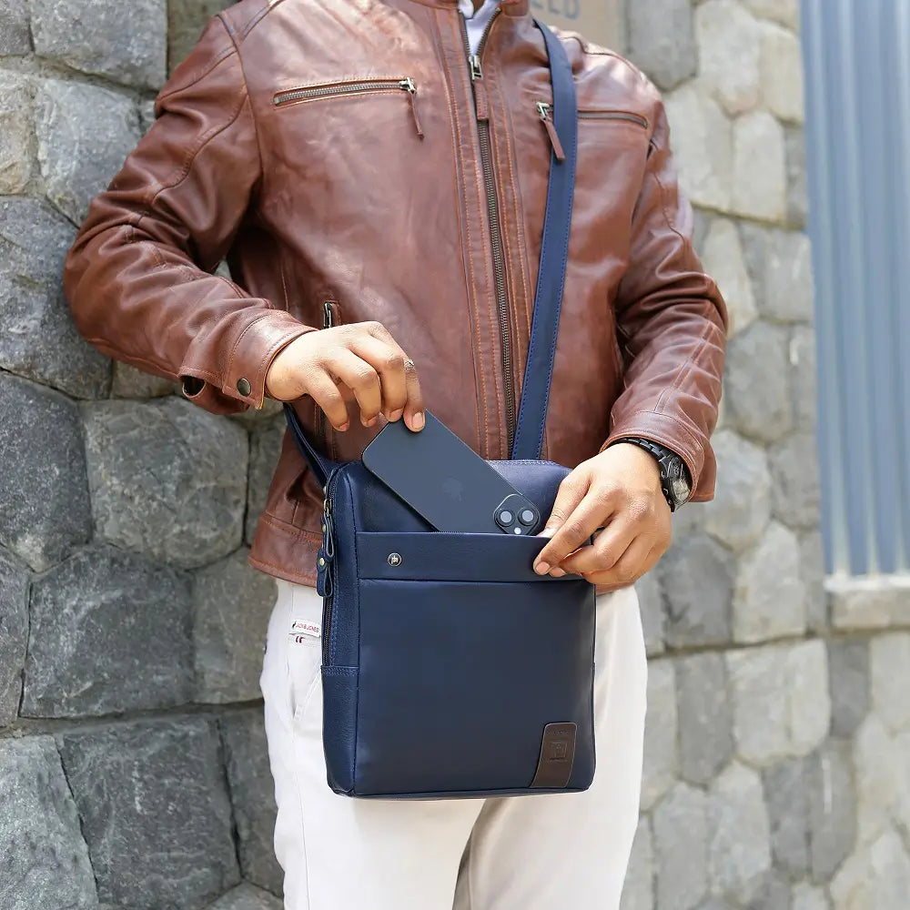 Person holding a blue messenger 
 bag against a stone wall