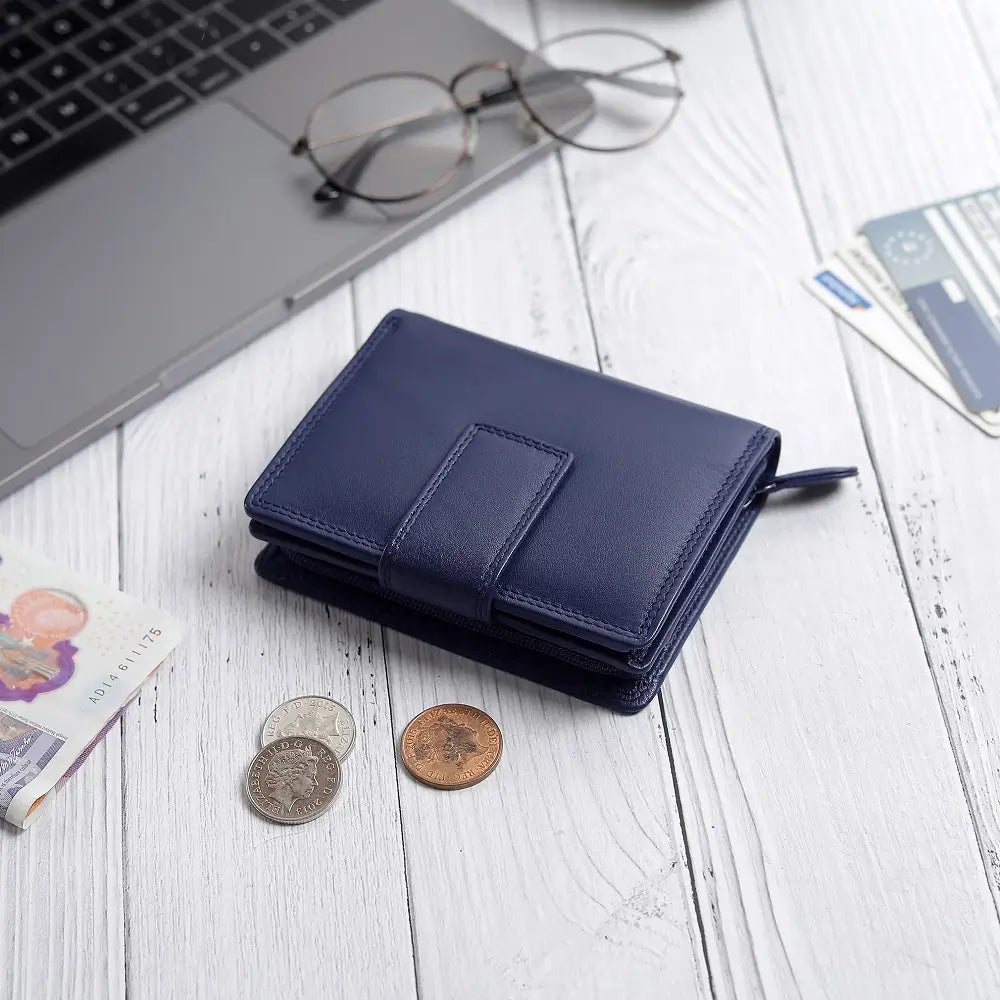 Soft navy leather trifold purse with secure tab fastening – flat lay view