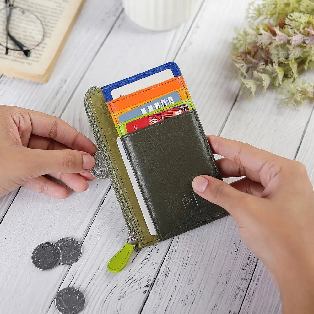 Person opening a Olive Leather cardholder purse  on a wooden surface with coins and cards visible