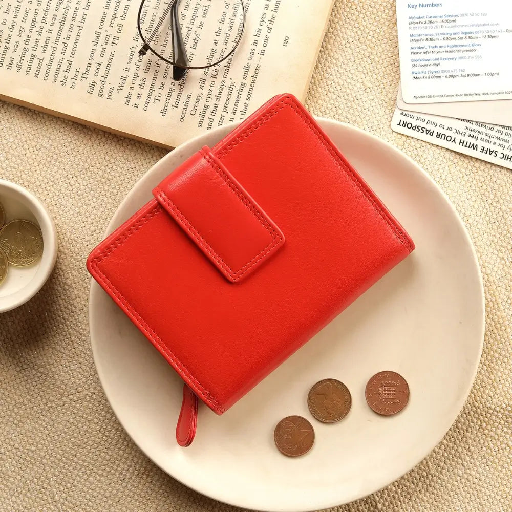 Soft orange leather trifold purse with secure tab fastening – flat lay view