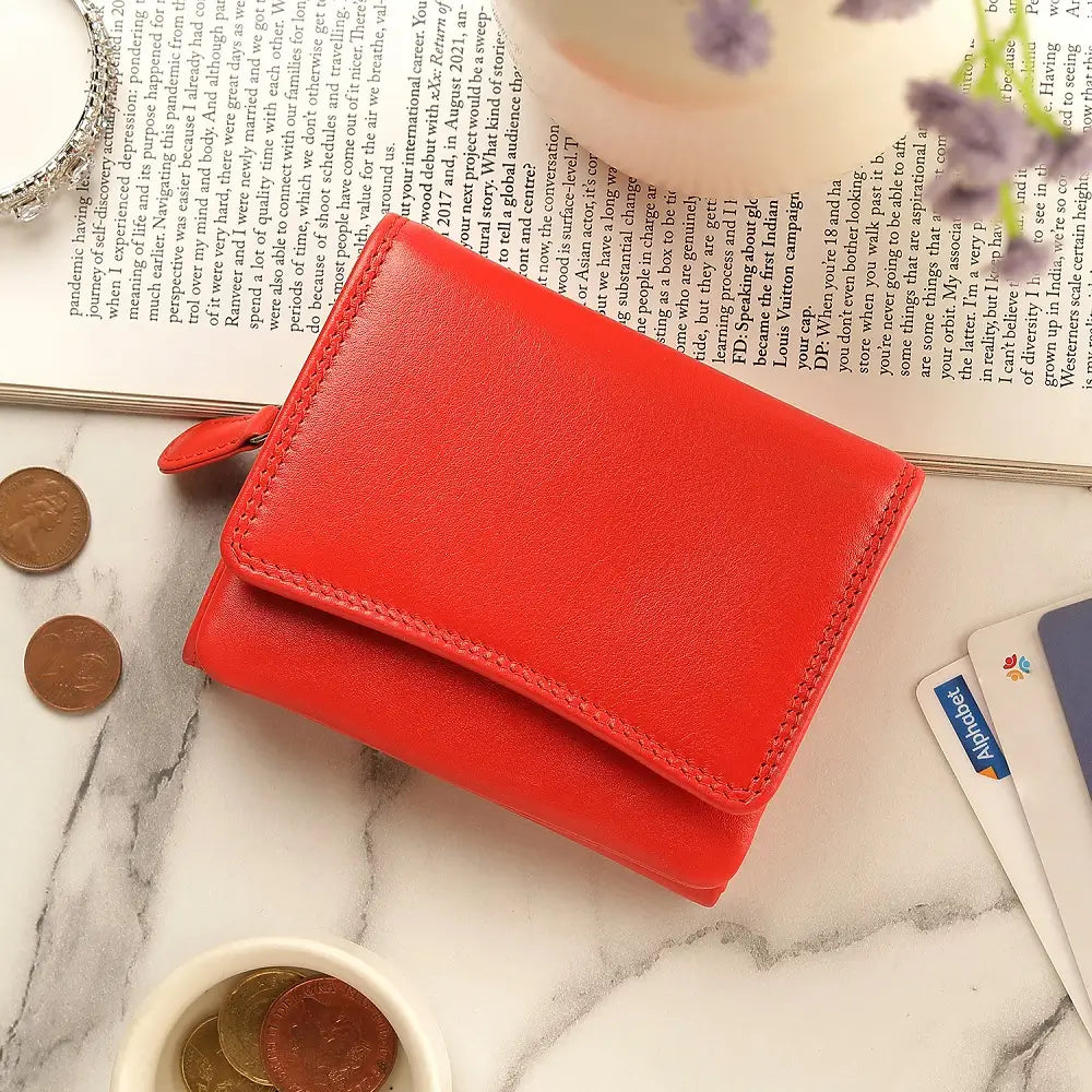 Orange wallet on a marble surface with coins and cards