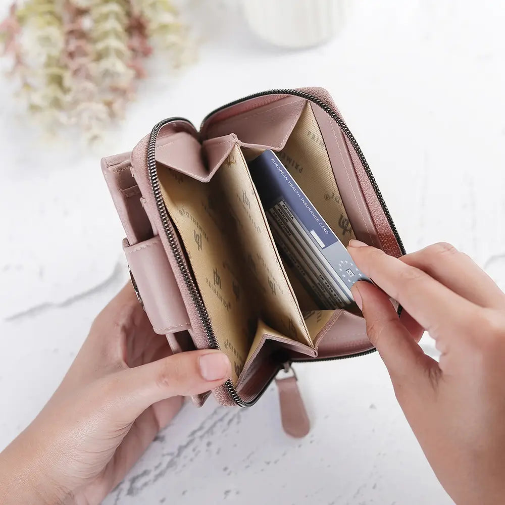 Person holding a pink wallet with cards on a light background