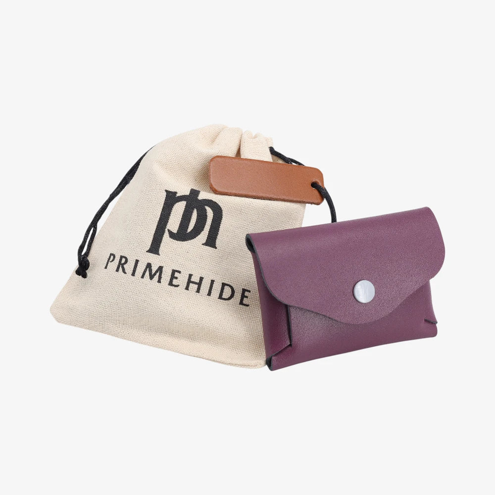 Plum leather coin purse with flap closed displayed beside Primehide dust bag