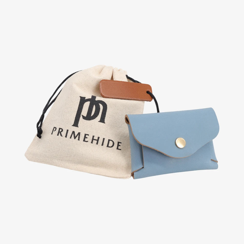 Powder blue leather coin purse with flap closed displayed beside Primehide dust bag