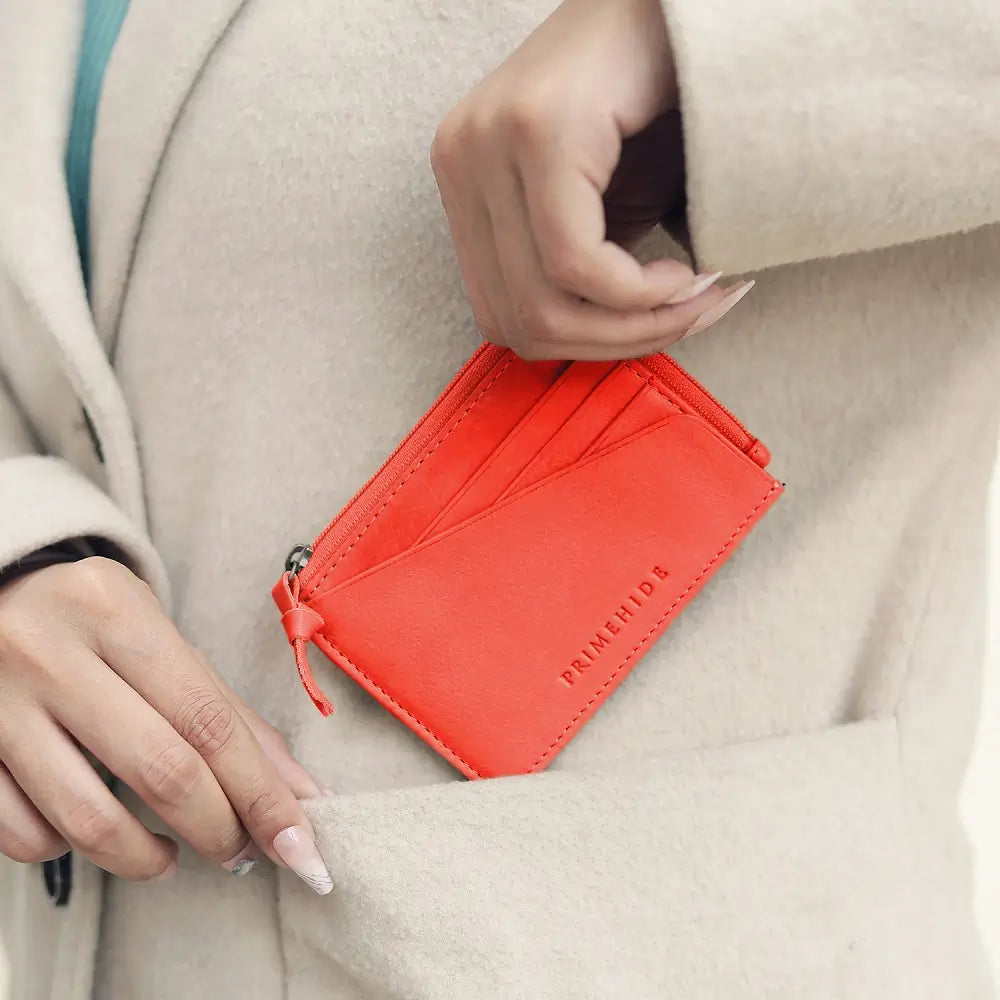 Person holding a red wallet with 'PRIMEhide' branding.