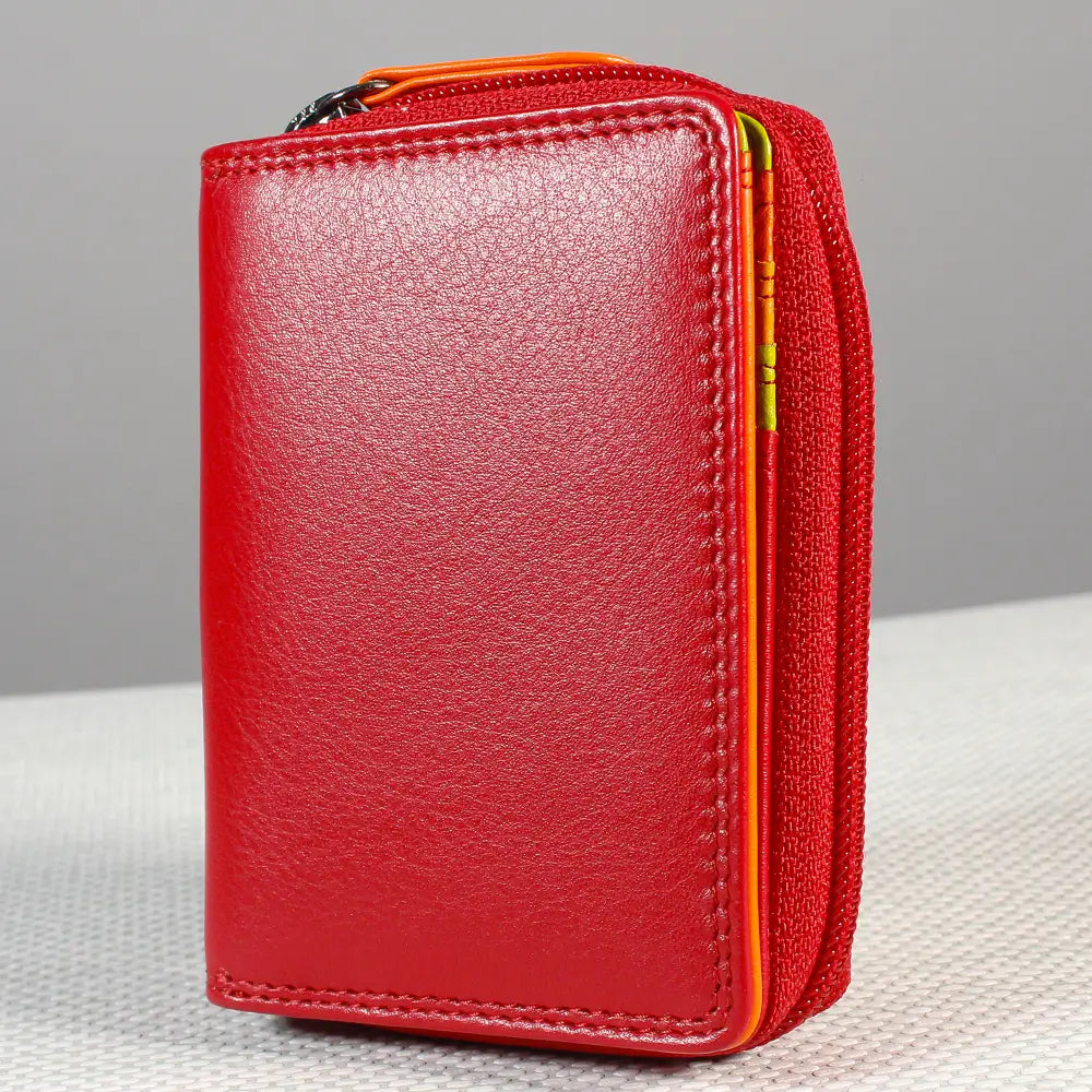 A red leather zip-around wallet with orange stitching and a matching red fabric card sleeve, shown on a light gray background.