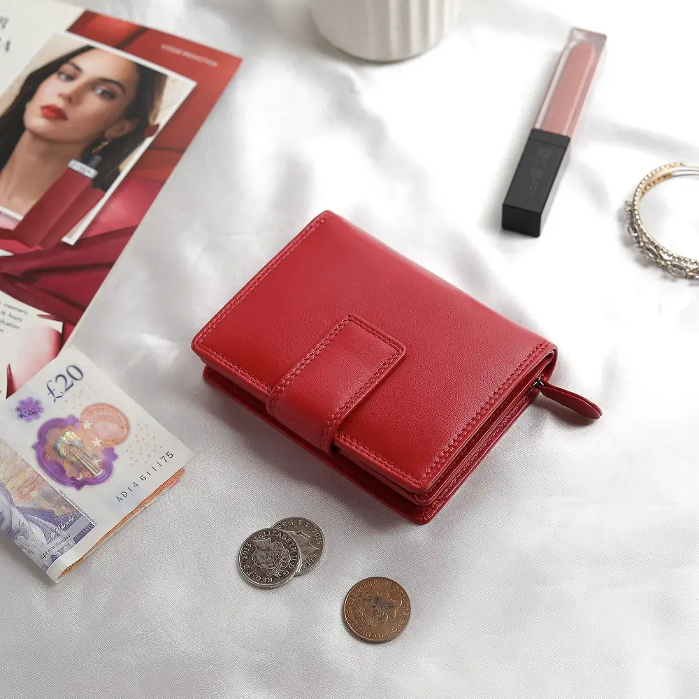 Soft red leather trifold purse with secure tab fastening – flat lay view