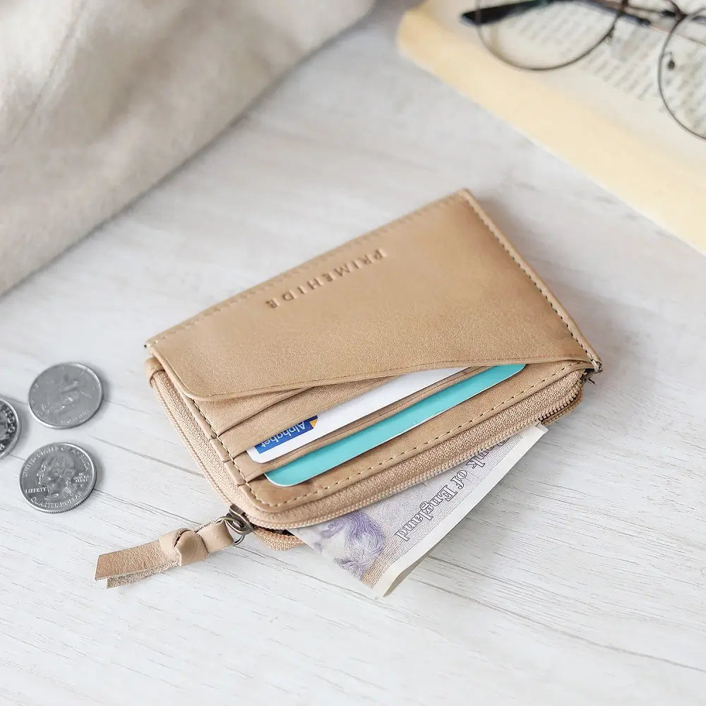 Sand wallet with coins and cards on a light surface
