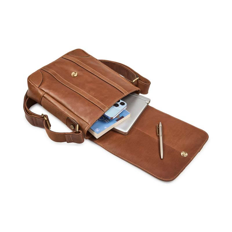 Brown leather bag with compartments holding a phone, tablet, and pen on a white background