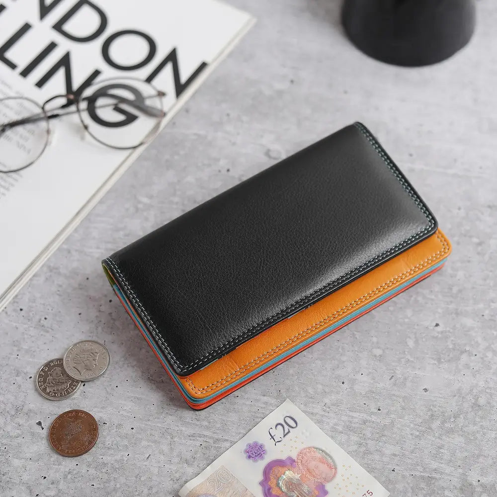 Black  wallet on a textured surface with coins and a banknote.