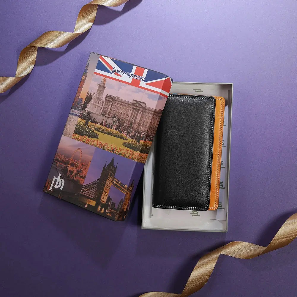 Black wallet with orange interior in a box, featuring a travel-themed passport cover on a purple background.