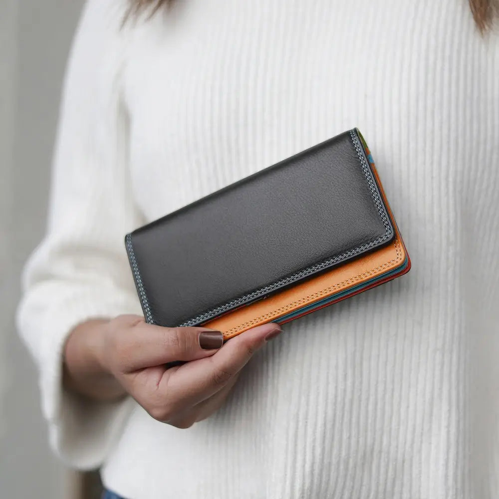 Person holding a two-tone leather wallet with a black top and orange bottom.