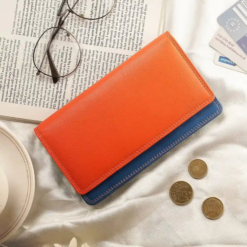 Orange wallet on a newspaper  with coins and a glasses.