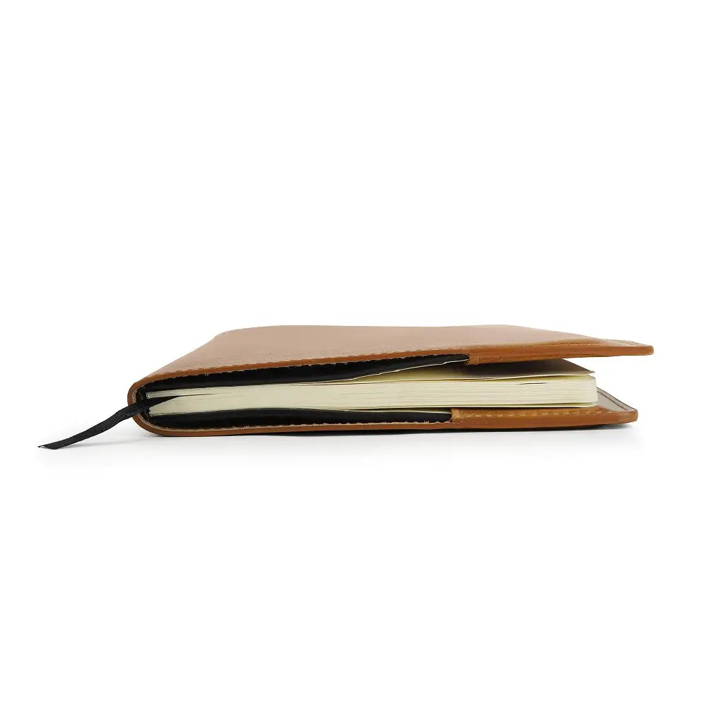 Tan leather diary cover with notebook on a white background