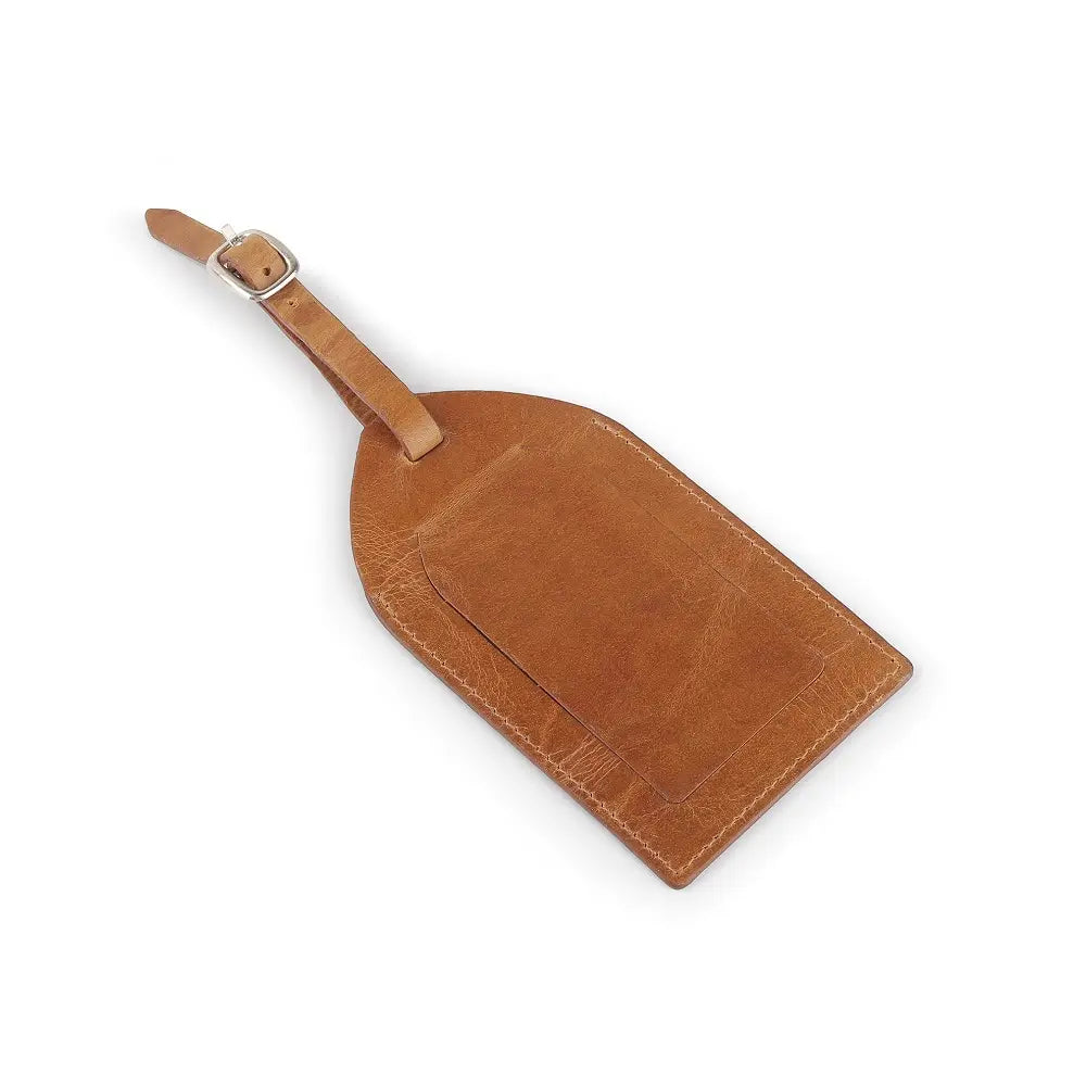 Top view of tan full-grain leather luggage tag showing ID window, flap cover, and buckle strap.