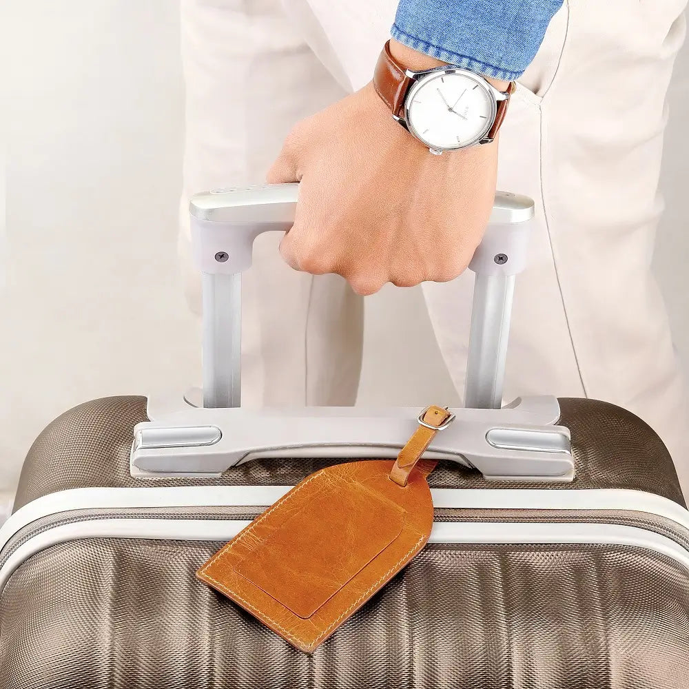 Tan leather luggage tag paired with a matching tan travel bag for coordinated luxury style.