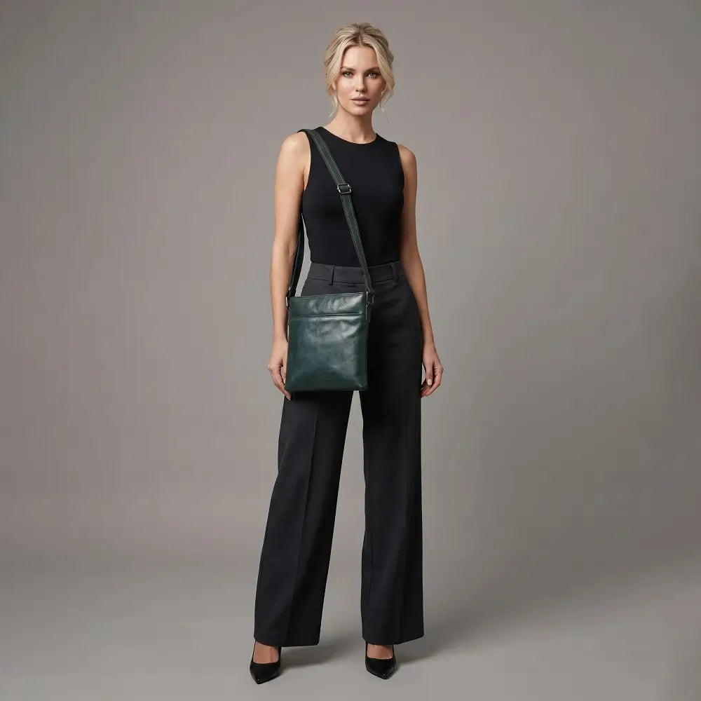 Woman holding a Teal leather bag against a gray background