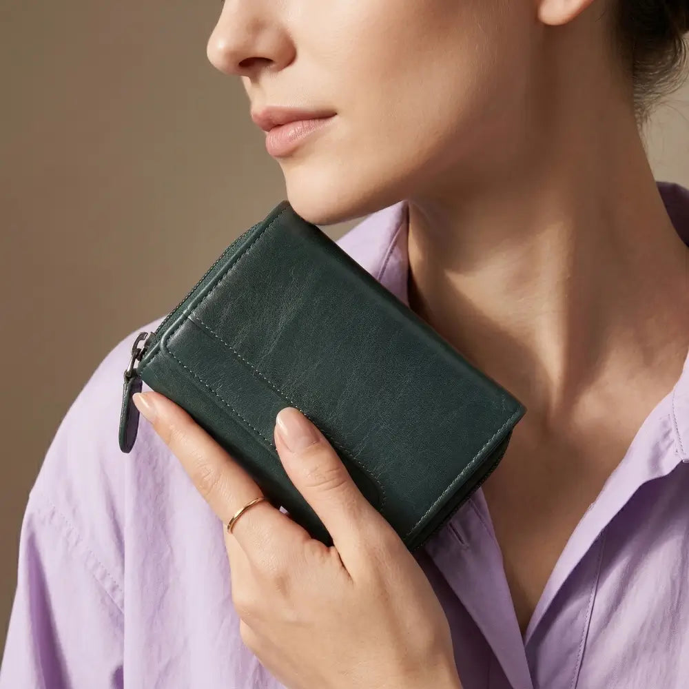 Person holding a Teal wallet against a neutral background