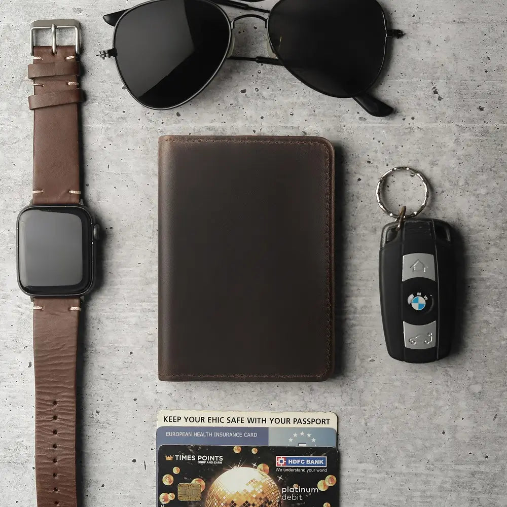 Collection of a watch, wallet, key fob, and card on a textured surface