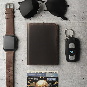 Collection of a watch, wallet, key fob, and card on a textured surface