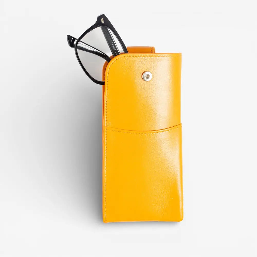 Yellow glasses case with a pair of glasses on a light gray background