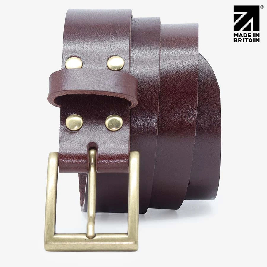 Close-up of the antiqued brass buckle on a brown full-grain Italian leather belt