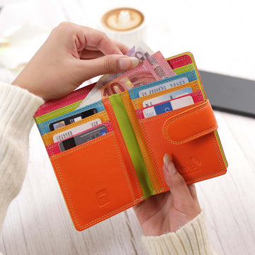 Green wallet with card slots held by a hand, blurred background