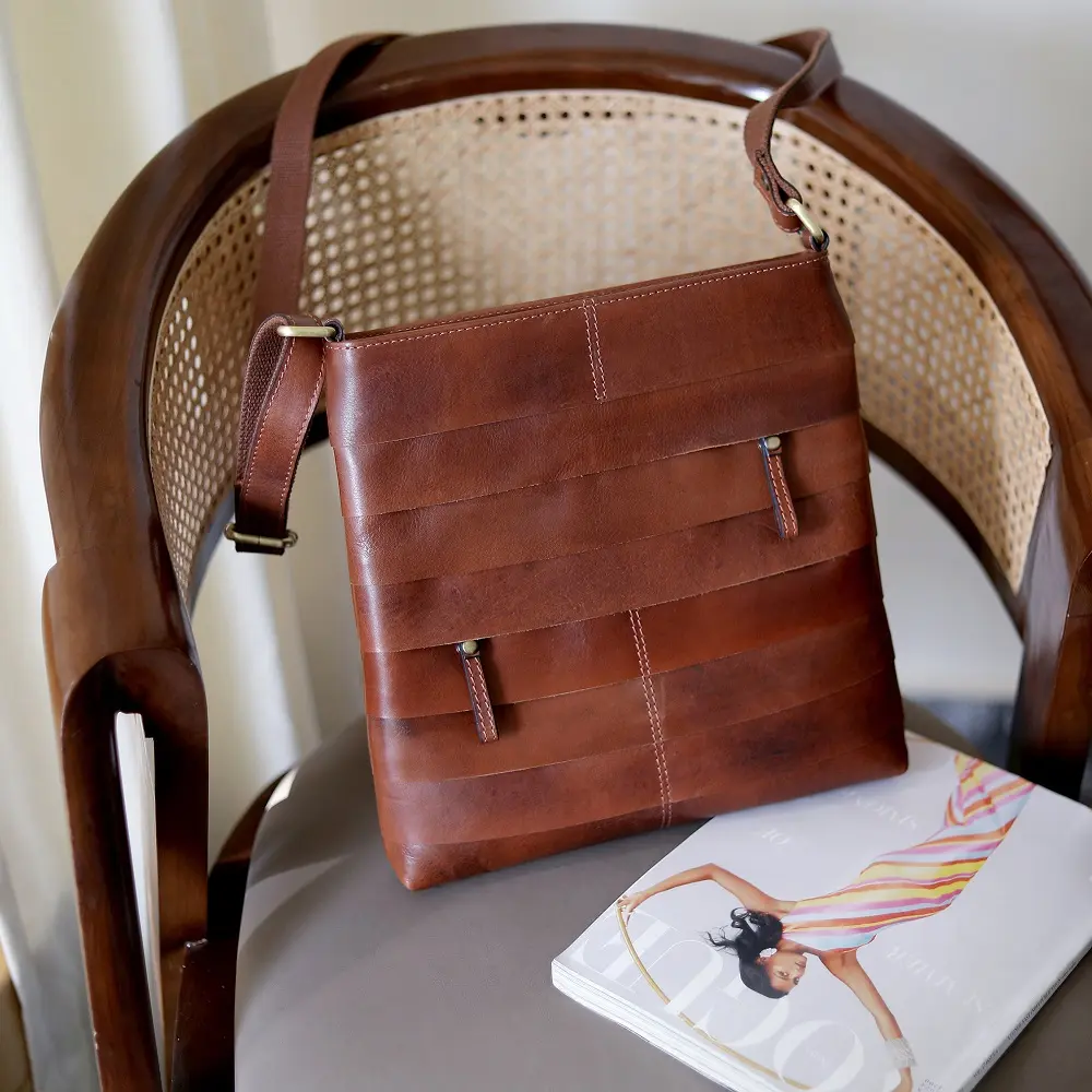 Boho Layered Leather Bag - Ridgeback displayed on a stylish cane chair, emphasising its rich distressed leather and handcrafted design, perfect as a timeless accessory.