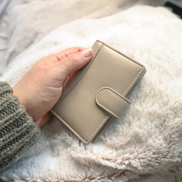 a woman is holding a soft leather card holder wallet