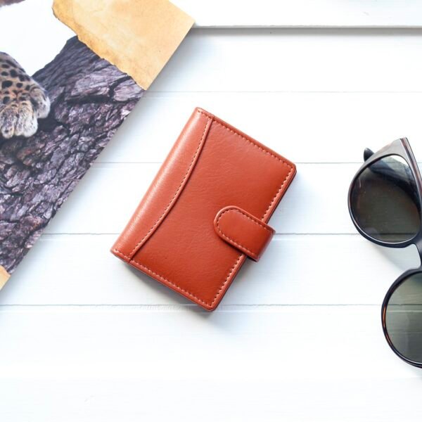 a tan coloured leather credit card holder on a white wood table