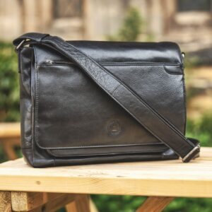 black leather messenger bag with an embossed front, there is a long crossbody strap.