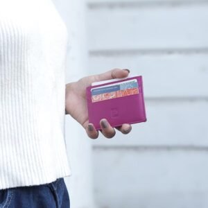 Person holding slim leather card holder with multiple cards inserted
