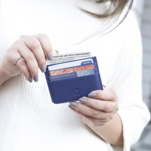 Person holding an indigo blue leather card holder with cards inserted